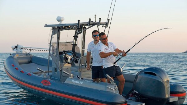 Scatto laterale di un gommone Joker Boat - Barracuda 650 mentre due uomini pescano.