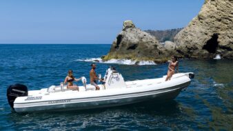 Scatto laterale di un gommone Joker Boat - Clubman 26 con a bordo tre persone.