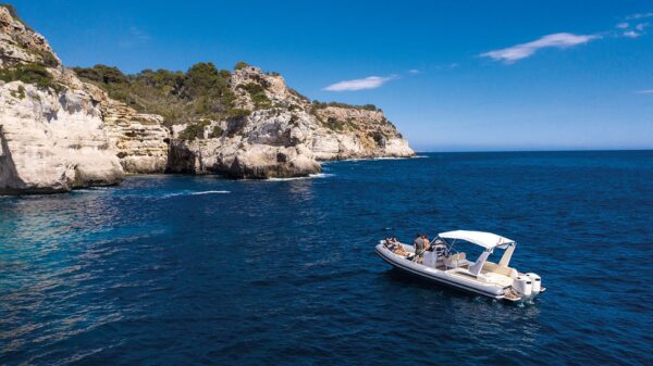 Scatto aereo laterale di un gommone Joker Boat - Clubman 28 con a bordo quattro persone.